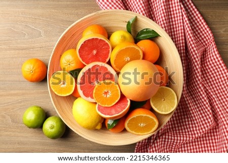 Different citrus fruits on wooden table, top view Royalty-Free Stock Photo #2215346365