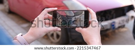 Woman holding smartphone and taking picture of car accident. Car insurance and payout concept