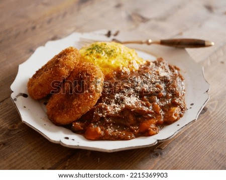 Omelette rice topped with curry and croquettes