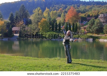 The photo was taken near the city of Truskavets in the Carpathians. The picture shows a young woman doing morning exercises on the shore of a mountain lake.