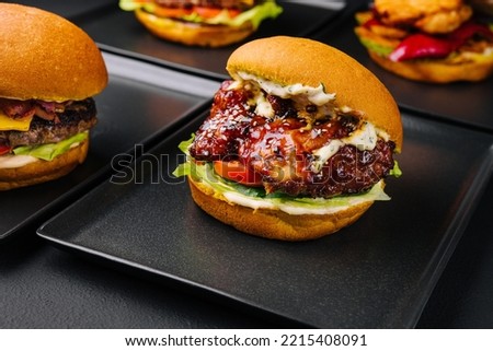 Appetizing crispy chicken burgers on black plates