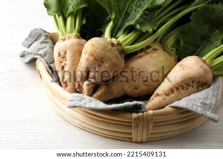 Basket with fresh sugar beets on white wooden table, closeup Royalty-Free Stock Photo #2215409131