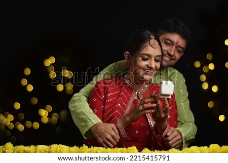 Happy Young couple celebrating diwali and husband giving gift to wife 