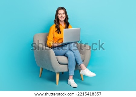 Full length portrait of positive nice person sit chair use wireless netbook isolated on blue color background