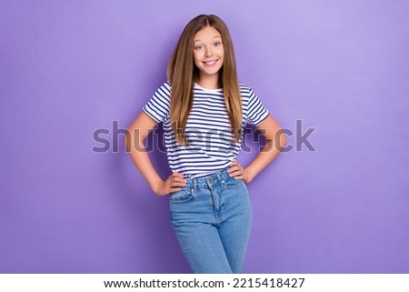 Photo of funny optimistic cute girl with straight hairdo wear striped t-shirt hold arm on waist isolated on purple color background