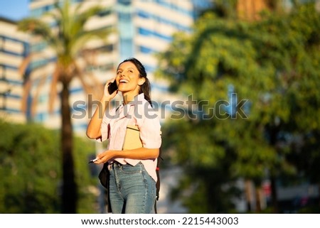 Portrait happy young woman talking with cell phone in city 