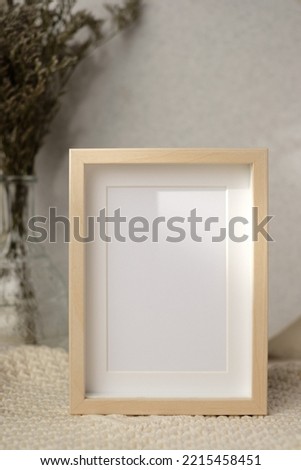 mockup photo frame with flower in vase on white soft wicker tablecloth