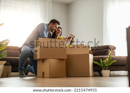 Happy young married couple moves to new apartment and unpaking boxes. Royalty-Free Stock Photo #2215474955
