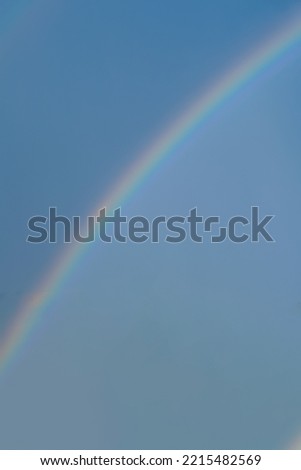 Rainbow over blue sky. Natural backgrounds. Vertical photo