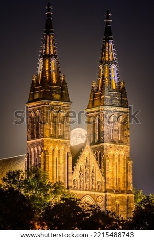 Full moon over the illuminated Basilica of St. Peter and St. Paul on Vysehrad hill in Prague.