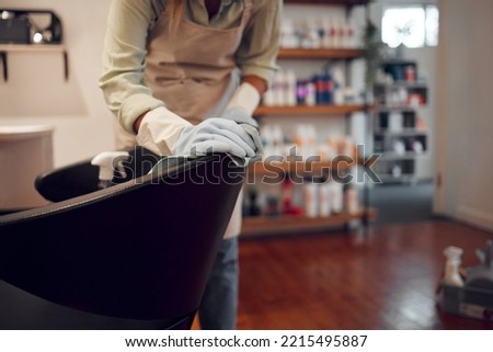 Salon, small business and woman cleaning chair with equipment in modern beauty parlor in city. Cleaner, maid or girl washing furniture at hairdressing shop with hygiene and sanitizing products. Royalty-Free Stock Photo #2215495887