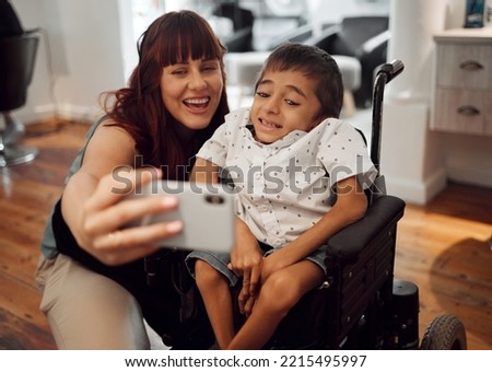 Child, cerebral palsy and happy phone selfie of a mobile disability boy in a wheelchair. Woman or mother smile with a young kid using technology to take a picture together with happiness and care Royalty-Free Stock Photo #2215495997