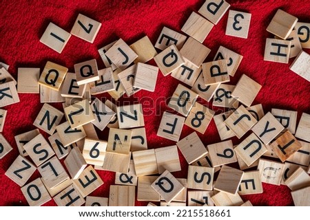 Black letters placed on wood. Small pieces of alphabet.