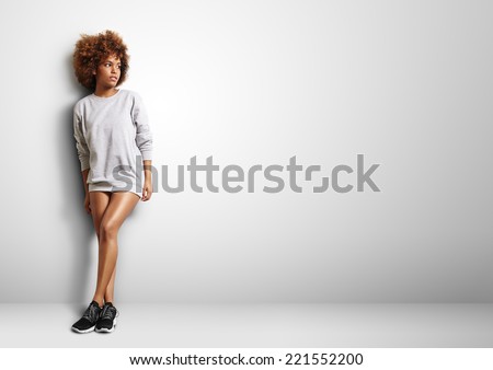 black woman with curly hair wearing sweatshirt like a dress