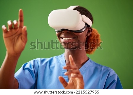 Female Nurse Or Doctor In Scrubs With VR Headset Interacting With AR Technology Against Green Screen Royalty-Free Stock Photo #2215527955
