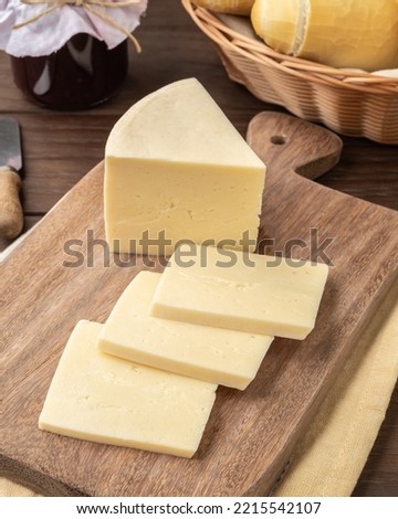 Artisanal Alagoa cheese from Minas Gerais, Brazil over a wooden board with bread and jam. Royalty-Free Stock Photo #2215542107