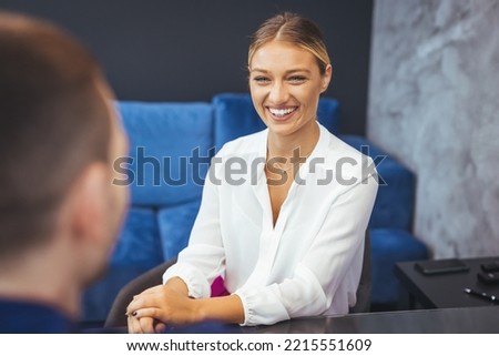 Woman having a business meeting and signing a contract, recruitment or agreement. Two business people discussing in office lounge. Businesswoman talking with a male colleague in office lobby.
