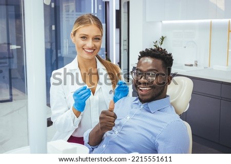 Unhappy african american man in medical chair complains of toothache to female dentist at modern dental clinic. Shot of a young man having a consultation with his dentist