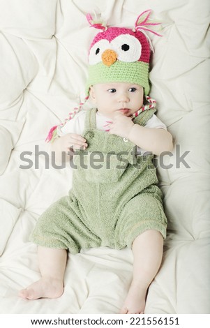 Portrait of cute happy 5 month old baby boy with funny hat. Photo of funny babe. 
