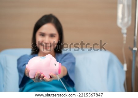 Asian woman patient lying on bed in hospital and holding piggy bank box, Medical healthcare money savings and insurance concept