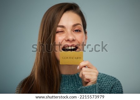 Winking woman in green sweater holding credit card.  Advertising female portrait.