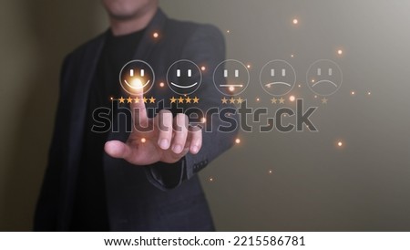 Selective focus at finger of business man while point finger to choose feedback on excellent customer service with five star score with smile. Service evaluation concept with futuristic icon.