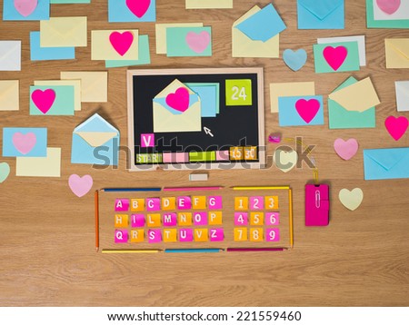 Desktop computer composed of colorful stationery with open mail.