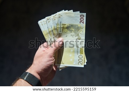 Euro bills in a man's hand isolated on a black background. High quality photo