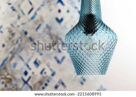 Blue lamp on the background of an Arabic geometric pattern on the wall