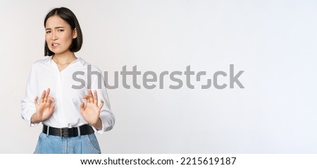 No thank you. Young disgusted asian woman declining proposal, shaking hands and step back, looking with dislike, rejecting offer, standing over white background. Royalty-Free Stock Photo #2215619187