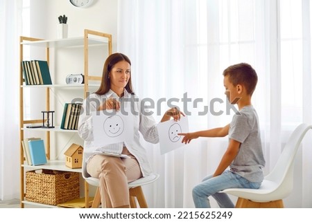 Psychologist or therapist working with child in office. Little boy meets with school counsellor for emotional intelligence test. Schoolchild chooses sad negative emoji. Psychology and children concept Royalty-Free Stock Photo #2215625249