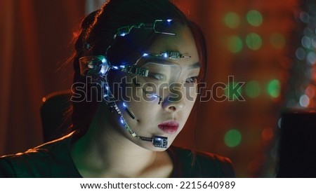 A Cyberpunk girl works on the computer in the red neon lights. Asian girl with futuristic one-eyed glasses and microphone. Cyber and sci-fi backgrounds.
