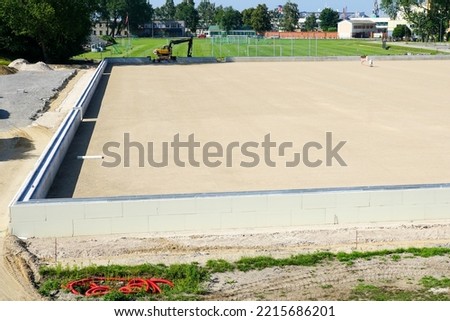 prepared base and concrete border for installation of inflatable playing arena, football hall, air dome on blue sky background Royalty-Free Stock Photo #2215686201