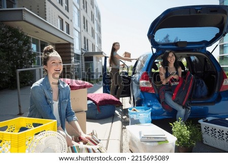 College students unloading car moving into college dorm