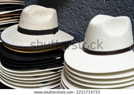 Panama hats piled up on street store. Men colorful accessories stack, souvenir concepts Royalty-Free Stock Photo #2215714733