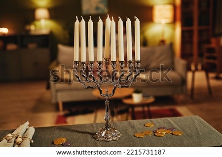 Background image of silver menorah candle in cozy home interior, copy space