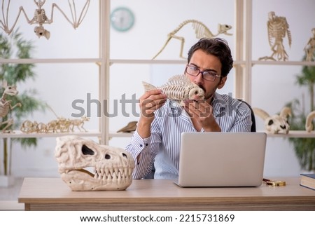 Young male paleontologist examining ancient animals at lab Royalty-Free Stock Photo #2215731869
