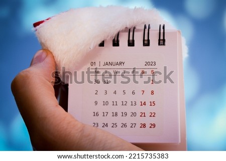 Not a big calendar with a Santa Claus hat in your hand. a ready-made Christmas and New year greeting card. On the calendar January 2023. High quality photo
