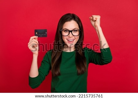 Photo of cute excited girl raise arms pay off loan dressed trendy green long sleeve shirt eyewear isolated on shine red color background
