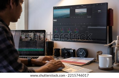 Cropped shot of male video editor  working on professional computer with video editing and color correction.
