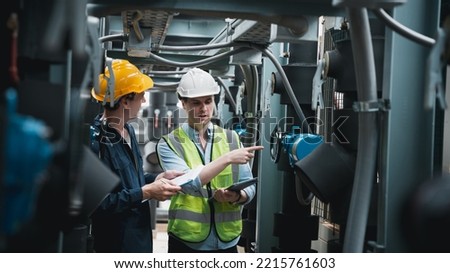 Engineer and team examining the air conditioning cooling system of a huge building or industrial site. Royalty-Free Stock Photo #2215761603
