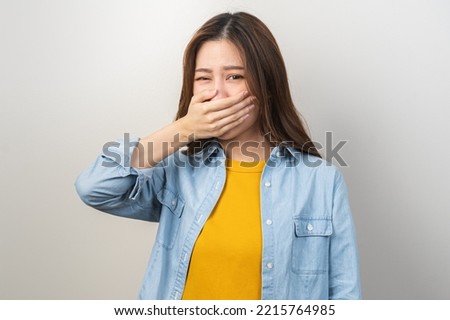 Portrait of pretty brunette hair, disgust smell bad breath strong asian young woman, girl covering, close her mouth with hand, expression face disgusting, dislike odor. Isolated on white background. Royalty-Free Stock Photo #2215764985