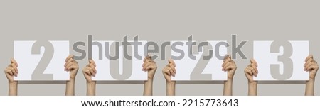 new year 2023. Women's hands hold signs with numbers two thousand twenty-third. Concept of welcome to the beginning of calendar year.