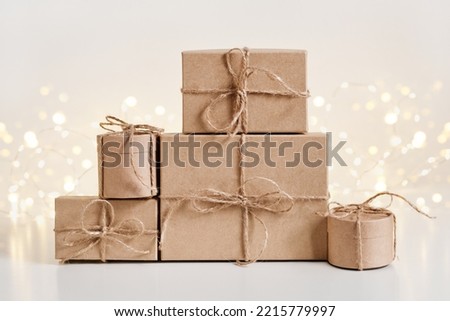 Christmas sustainable gift boxes composition on shining bokeh background. Christmas zero waste, boxing day and winter holiday.