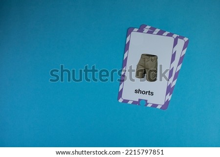 Short trousers photo flashcard placed on top right of blue background.