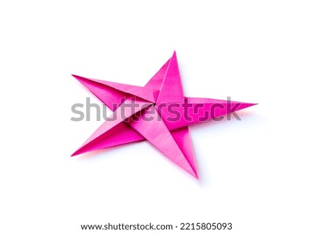 Pink paper star origami isolated on a blank white background.