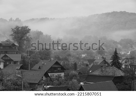 fog and smoke over the village in the morning in black and white
