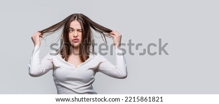 Messy hair. Frustrated woman having a bad hair. Woman having a bad hair, her hairs is messy and tangled. Girl having a bad hair. Bad hairs day. Brunette woman with messed hairs. Royalty-Free Stock Photo #2215861821