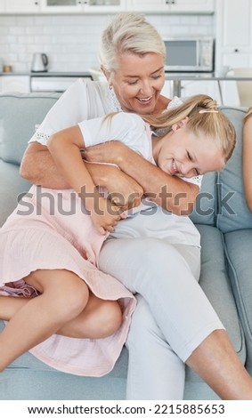 Grandmother, family and child at home with a senior woman having fun, bonding and laughing for tickle and playing on living room sofa. Grandma and girl grandchild spending time in Australia house