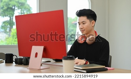 Handsome male photo editors sitting in creative workplace and retouching photos on personal computer